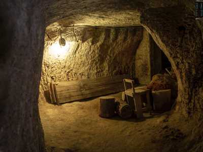 Proseguiamo tra gli scavi nella pietra e, superato un ambiente con una sedia e pezzi di legno che ricordano quasi un alloggio segreto